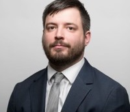 Photo of Steven Robinson wearing a suit. He has straight brown hair and a beard.